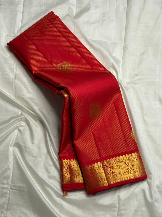 Thilakam Red Vairaoosi — Pure Silk Kanchipuram Saree
Radiant vermilion-red body with gold vairaoosi pinstripes and paisley buttas, paired with a fiery orange-red brocade pallu and grand peacock–elephant zari border ✨
Silk Mark Certified • Fall & Pico Done