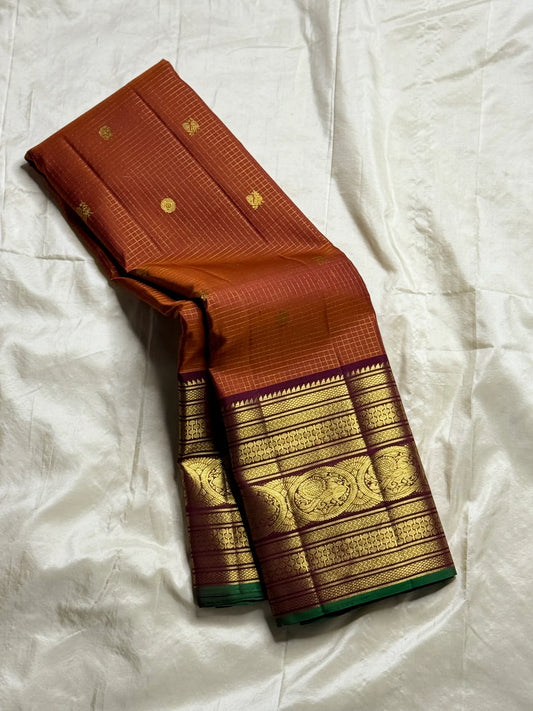 Rust Orange Pakshi Kattam – Pure Korvai Kanchipuram Silk Saree
Rust-orange micro-checked body with zari rosette & mango buttas
Plum korvai border with pakshi medallions & emerald selvedge; ships in two w
Silk Mark Certified | blouse Stitching available