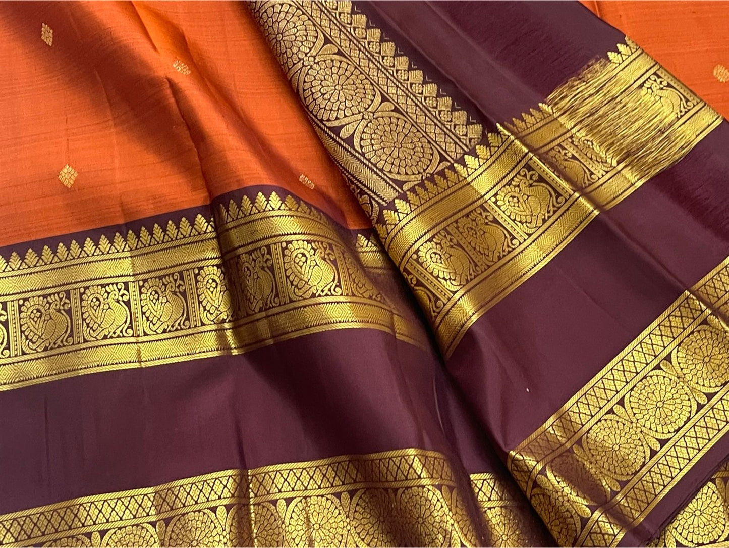 Rust Orange Ramyam – Pure Kanchipuram Silk Saree
Rust-orange body with pavin coin  buttas
Deep brown border with peacock panel & chakra medallions; grand zari pallu
Silk Mark Certified | Blouse Piece Included | Fall & Pico Done
Free Shipping in 1 week