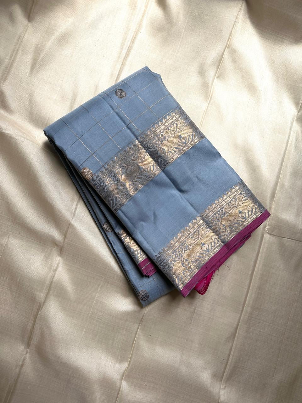 Fuchsia in Sky – Pure Silk Kanchipuram Saree
Sky Blue Body with Gold Kattam Checks & Petite Buttas
Fuchsia Contrast Petni Pallu with Zari Reku Stripes
Wide Gold Zari Border with Peacock & Temple Motifs
Silk mark certified, ships in 2 weeks