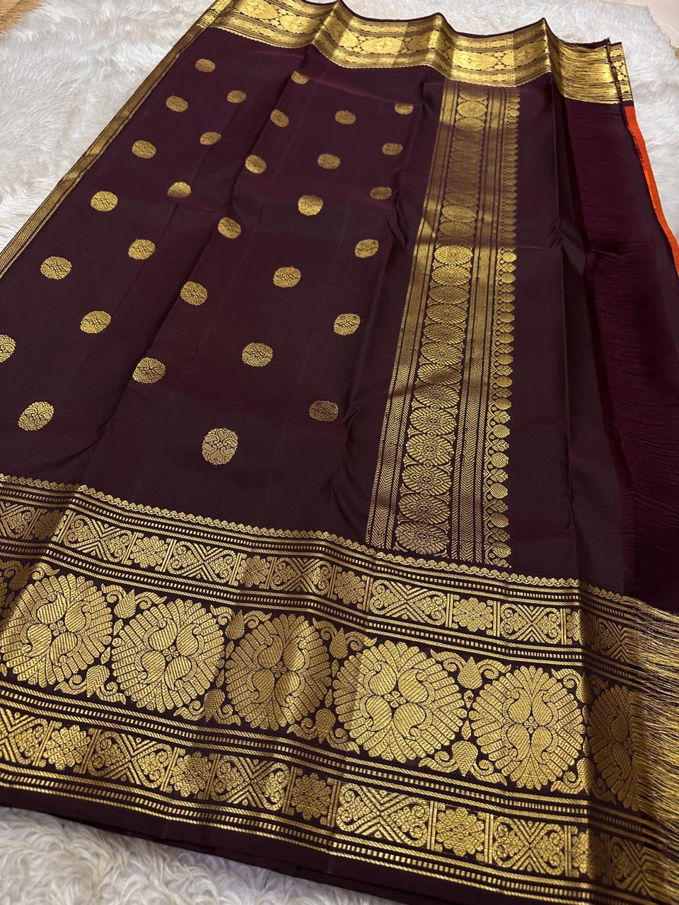 Rust Orange Coffee Brown — Flower Butta | Pure Kanchipuram Silk Saree
Rust-orange body with dainty zari-woven flower buttas and grand coffee-brown korvai borders rich in antique-gold floral medallions.
Silk Mark Certified • Blouse Stitching Available ($30