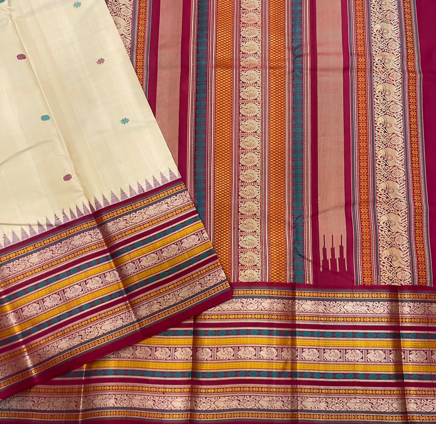 Pari Silk Thread Weaving — Pure Silk Kanchipuram
Ivory body with multi-color silk thread buttas (teal, wine & magenta)
Korvai contrast wine-magenta borders with vintage thread stripe panels
Temple gopuram inner edge & grand pallu in handwoven silk thread