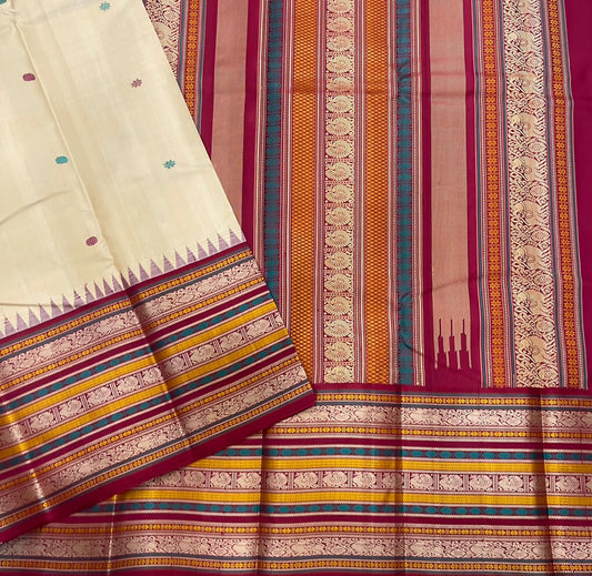 Pari Silk Thread Weaving — Pure Silk Kanchipuram
Ivory body with multi-color silk thread buttas (teal, wine & magenta)
Korvai contrast wine-magenta borders with vintage thread stripe panels
Temple gopuram inner edge & grand pallu in handwoven silk thread
