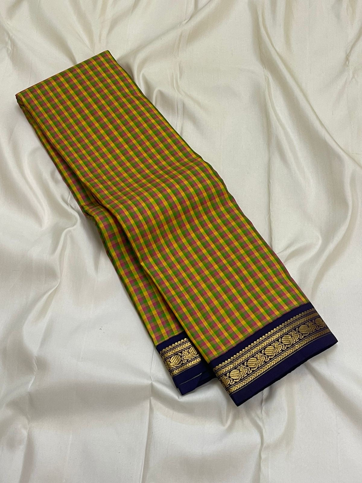 Forest Blossom Kattam — Pure Silk Kanchipuram Saree
Parrot-green, rani-pink & haldi-yellow kattam checks
Deep navy korvai borders with antique gold zari vines
Rich navy zari-striped pallu with tasseled edges
Silk Mark Cert • Free USA Shipping 1 week
