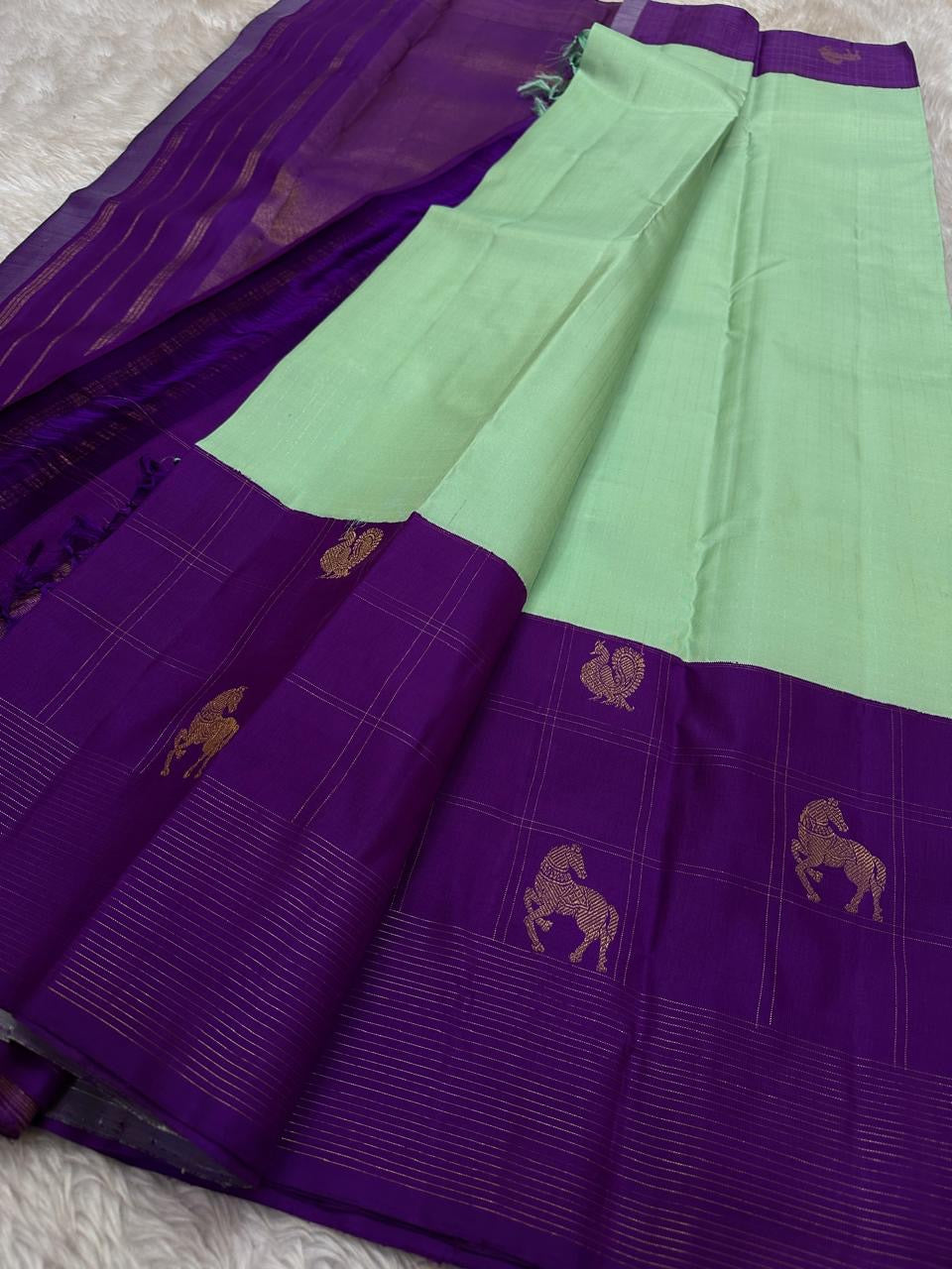 Ashva ✨ – Violet & Mint Pure Silk Kanchipuram Saree
Gold Zari Horse & Rooster Motifs in Kattam Checks
Linear Zari Border with Grand Violet Striped Pallu
Mint Green Blouse with Zari Border Included
Silk Mark Certified | Fall & Pico | Blouse Stitching ($30)