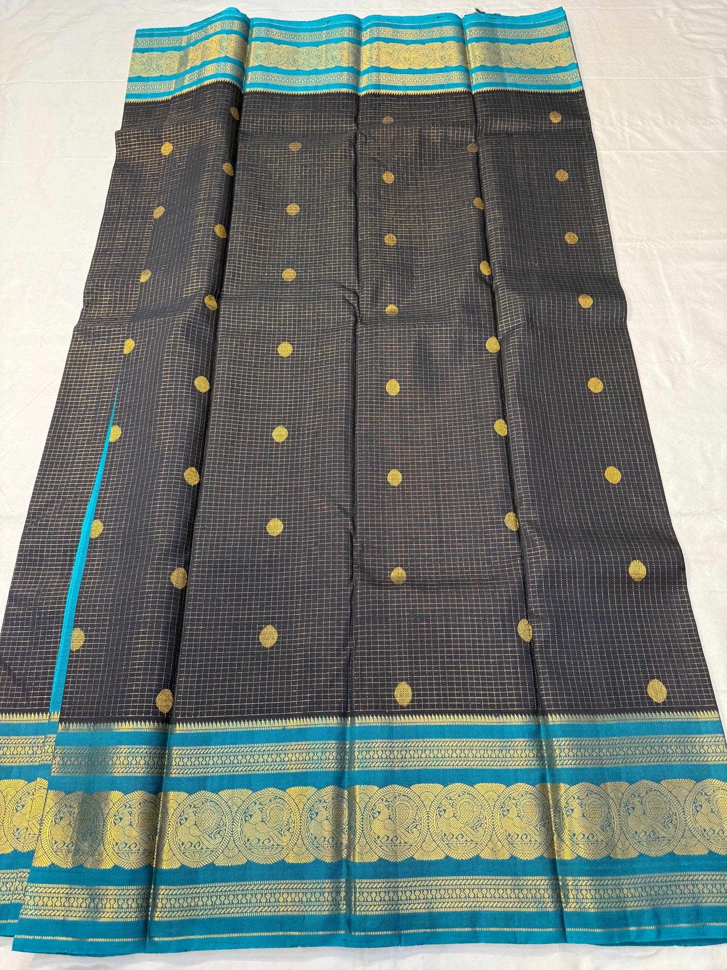 Karuppu Pakshi Kattam – Pure Korvai Kanchipuram Silk Saree
Charcoal black podi kattam body with coin-gold buttas
Peacock-teal korvai border & pallu with pakshi medallion zari
Silk Mark Certified | Blouse Piece Included | Fall & Pico Done
Free Shipping