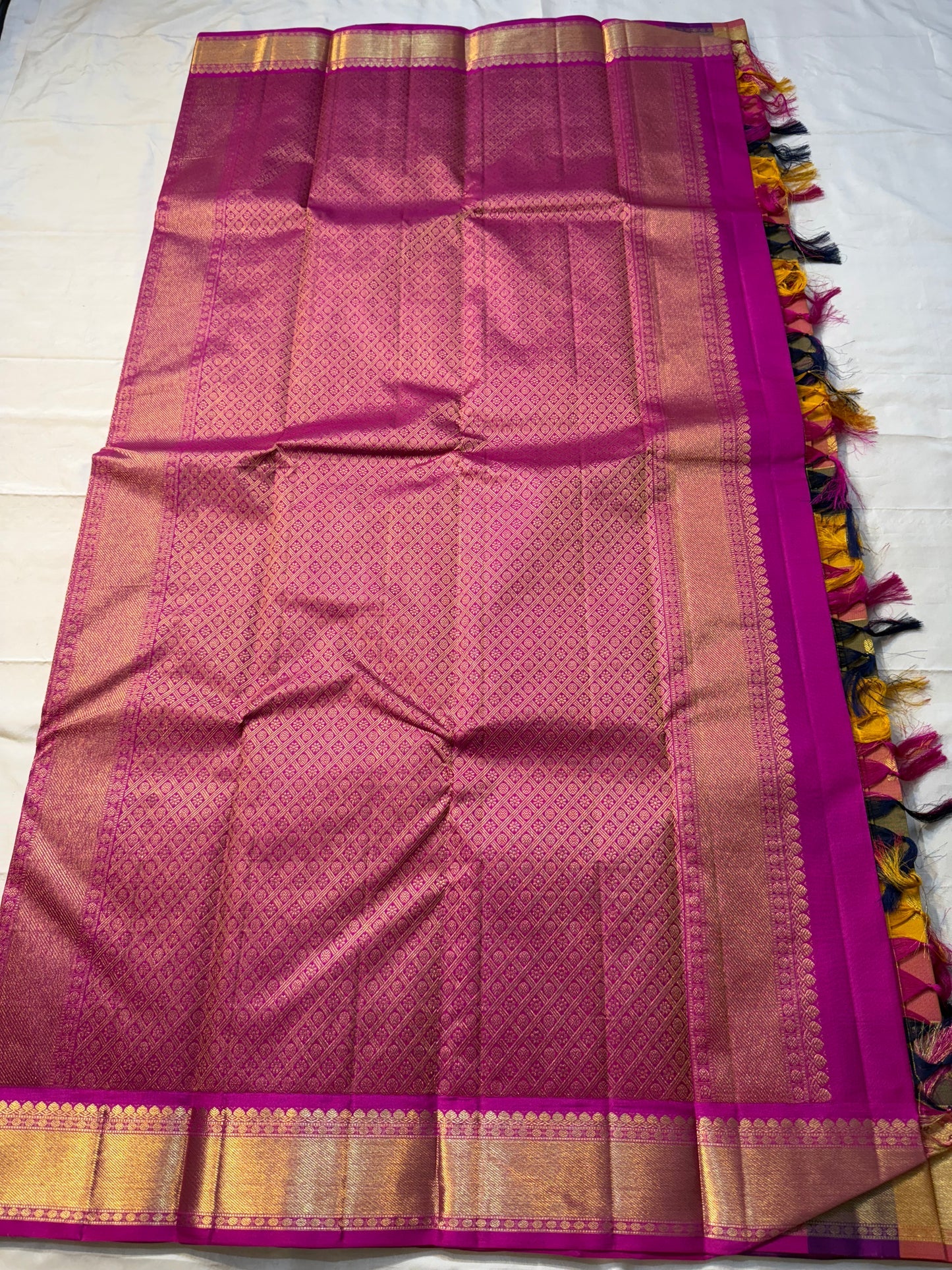 Navaranga Kattam — Multi-Color Paalum pazhamum checks  Kanchipuram Pure Silk
Rani-magenta contrast border & rich zari pallū 
Gold coin & peacock buttas over jewel-tone squares
Handloom Kanchipuram • Matching magenta blouse with borders