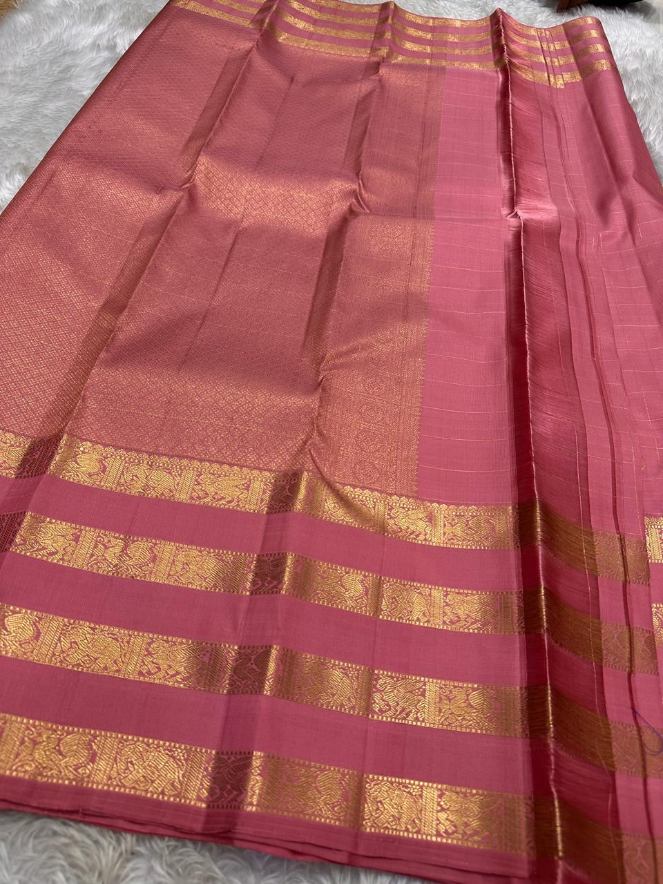 vasantham pink – Handwoven Kanchipuram Silk Saree
A poem in pink silk. The body glows in a serene rose pink, softly accented by delicate gold vertical lines and dainty gold zari buttas that glint like little blessings.