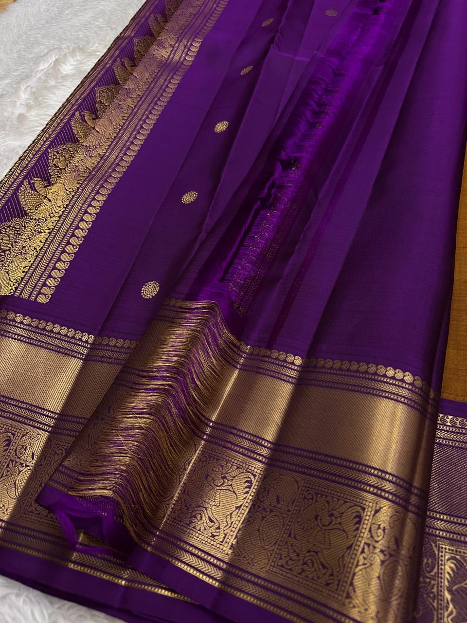 Ponvandu & Purple Butta — Pure Kanchipuram Silk Saree
Antique mustard body with gold zari buttas & rich purple borders
Peacock-woven zari motifs and temple serrations across the grand pallu
Silk Mark Certified • Free Shipping within USA • Ships in Two Wee