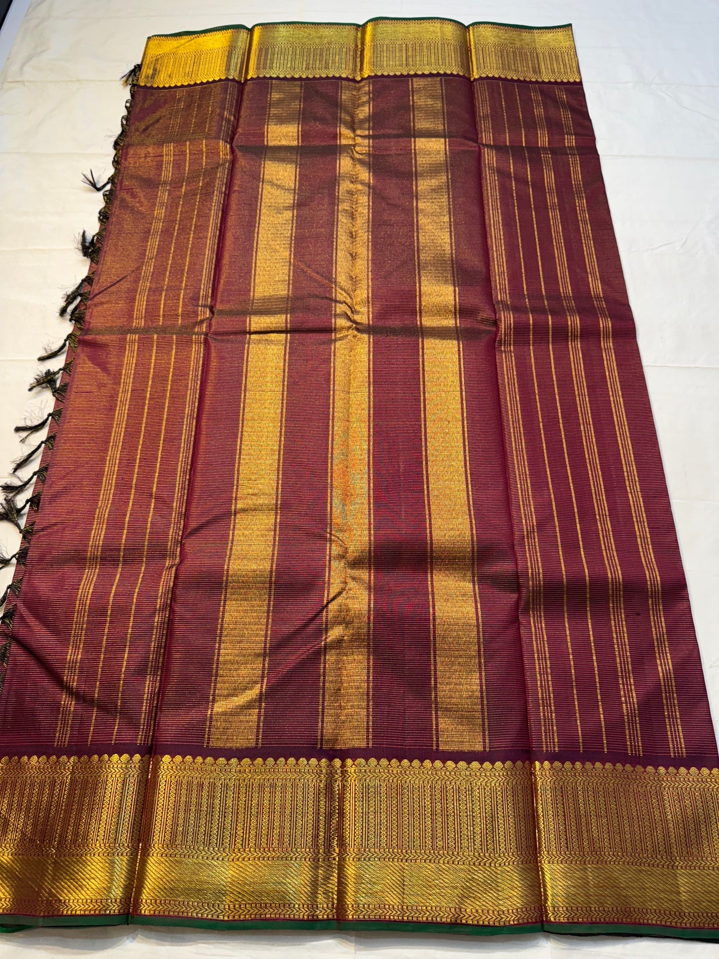 Shyama Vairaoosi — Pure Silk Kanchipuram
Deep Shyama brown with micro Vairaoosi pinstripes
Temple-column antique gold zari border, bottle-green selvedge
 Grand striped zari pallu with hand-tied tassels
Silk Mark Certified • free shipping