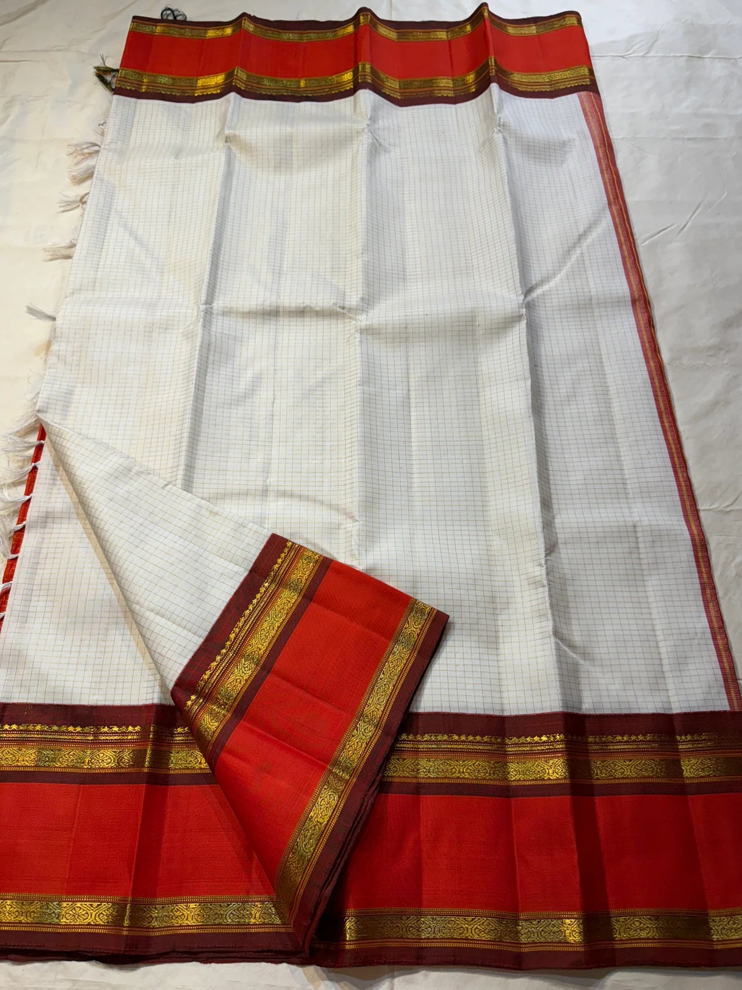 Shveta Arakku Kattam
Pure Silk Kanchipuram Saree – White Body with Fine Kattam Checks
Contrast Arakku Red Border & Maroon Korvai with Rich Zari Weave
Grand Zari Pallu Featuring Intricate Traditional Motifs
Silk Mark Certified ✅ Fall & Pico Done