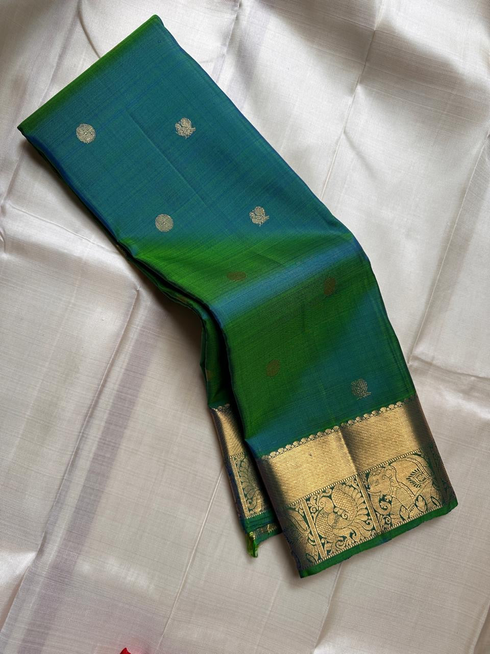 Dia ✨ – Vibrant Peacock Green Kanchipuram Pure Silk Saree
Gold Zari Buttas Adorning the Body
Intricate Gaja–Annam (Elephant & Peacock) Motif Border
Coordinated Peacock Green Silk Blouse Piece Included
Silk Mark Certified | Fall & Pico Done | Ready to Ship