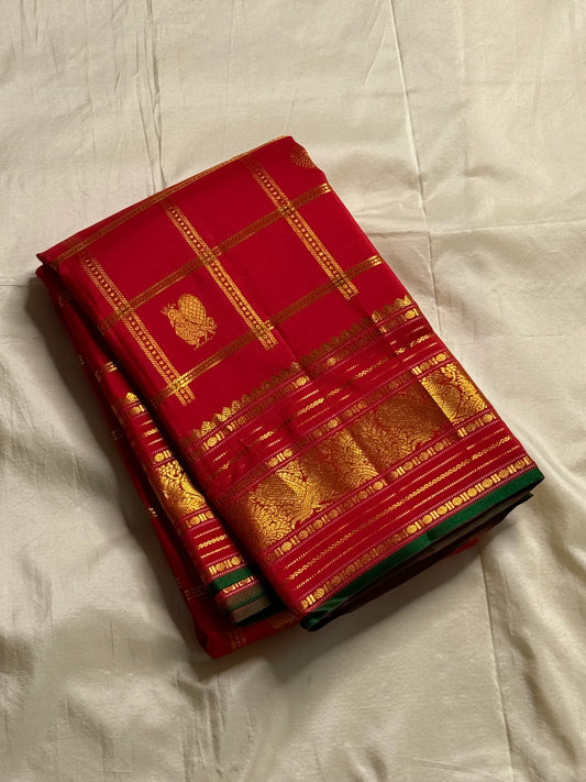 Ravi Kiranam — Sona Roopa Kattam Kanchipuram Pure Silk
Vibrant festive red body with allover kattam (grid) checks
Gold & silver sona-roopa zari alternating for a soft shimmer
Grand kaddi border with rich zari paisley vines & floral tracery
Silk Mark