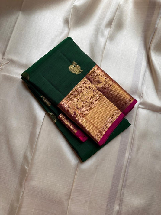 Maragatha Mayil Butta — Kanchipuram Pure Silk
Emerald green (maragatham) body with gold mayil/peacock buttas
Contrast rani-magenta korvai borders & zari-rich pallu
Silk Mark Certified | Free Shipping within USA