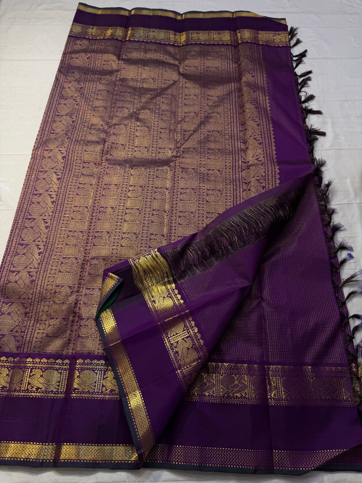 Kalika Purple — Pure Silk Kanchipuram Saree
Royal Purple with Gold Coin & Kalika Paisley Zari Buttas | Annapakshi Panel Border | Brocade Pallu
**Silk Mark Certified ✅ •ships in 2 weeks