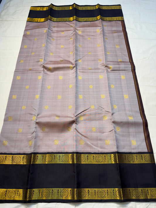 Ash Rose Butta — Pure Silk Kanchipuram
• Dusty ash-rose body with gold buttas
• Inky-black broad borders with antique-gold zari
• Black contrast pallu with zari stripe panels & tassels
• Silk Mark Certified • Ships in Two Weeks • Free Shipping within