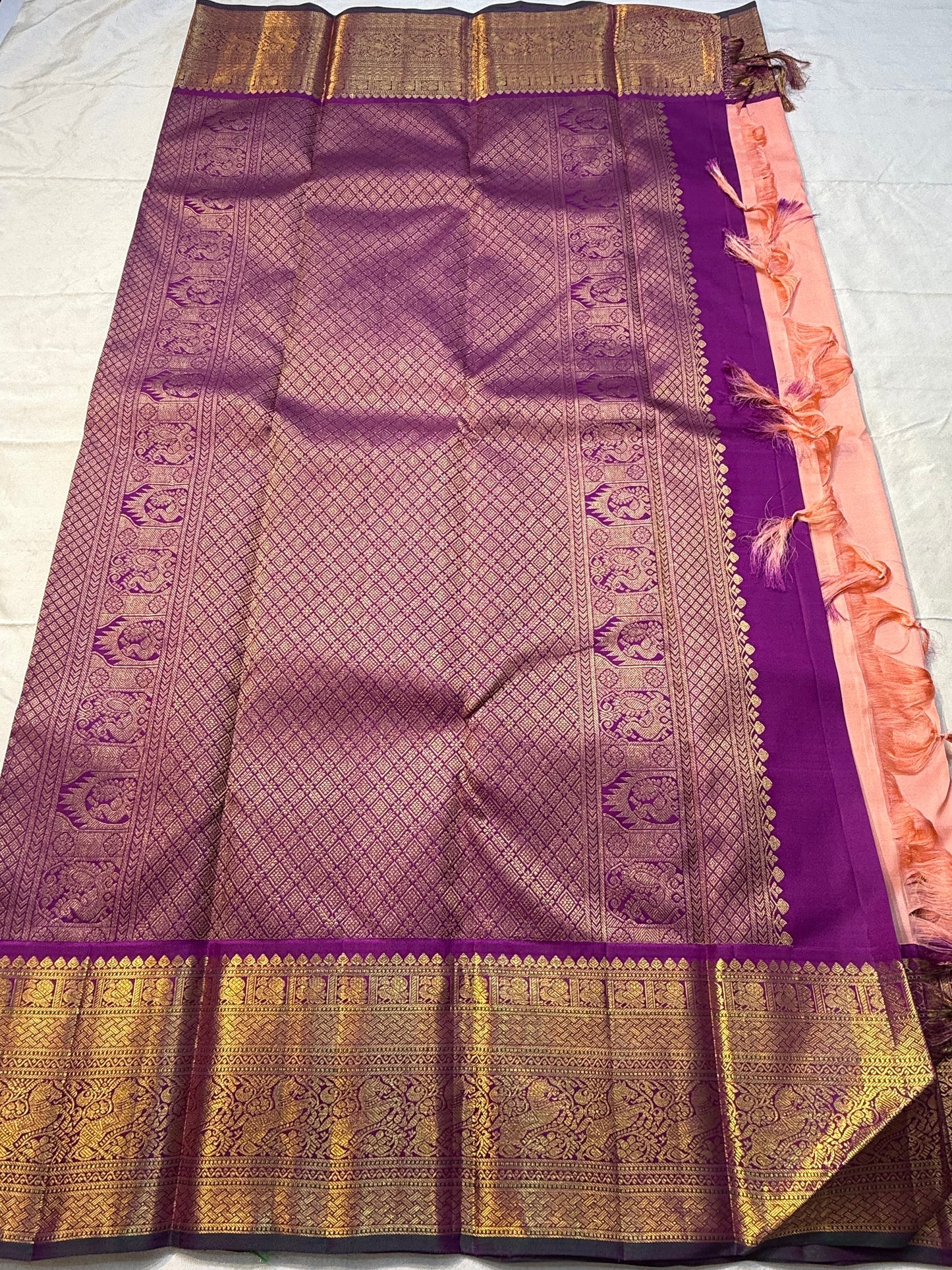 Apricot Yazhi — Pure Silk Kanchipuram Saree
Soft apricot-peach body with royal-purple korvai border featuring antique-gold Yazhi & Mayil motifs and temple edges.
Silk Mark Certified • Blouse Stitching ($30) • Free USA Shipping • Ships in 2 Weeks