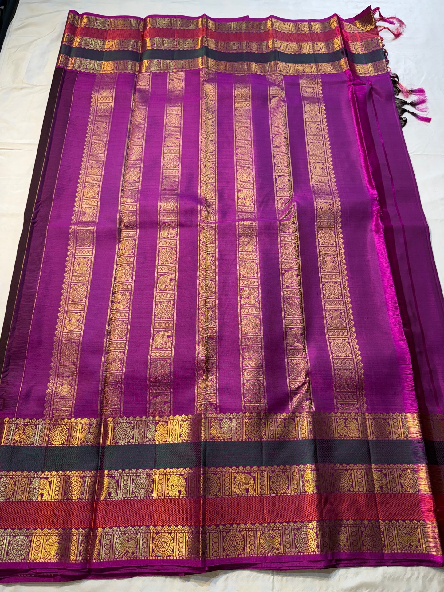 Coffee Brown Rajam – Pure Kanchipuram Silk Saree
Coffee Brown Body with Gold Zari Buttas
Rani Pink Korvai Borders with Temple, Peacock & Elephant Motifs
Grand Rani Pink Zari Brocade Pallu with Vertical Stripes & Tassels
Silk Mark | ships in two weeks