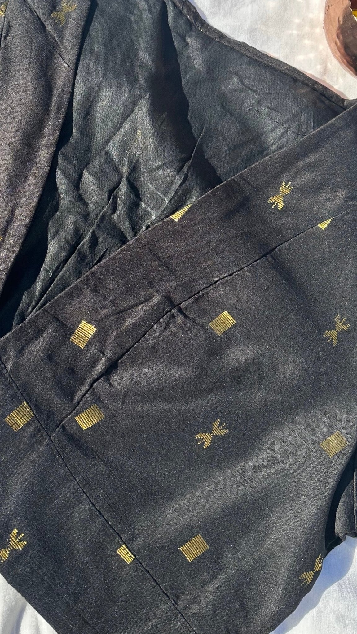 Black and gold silk blouse front view showing structured neckline