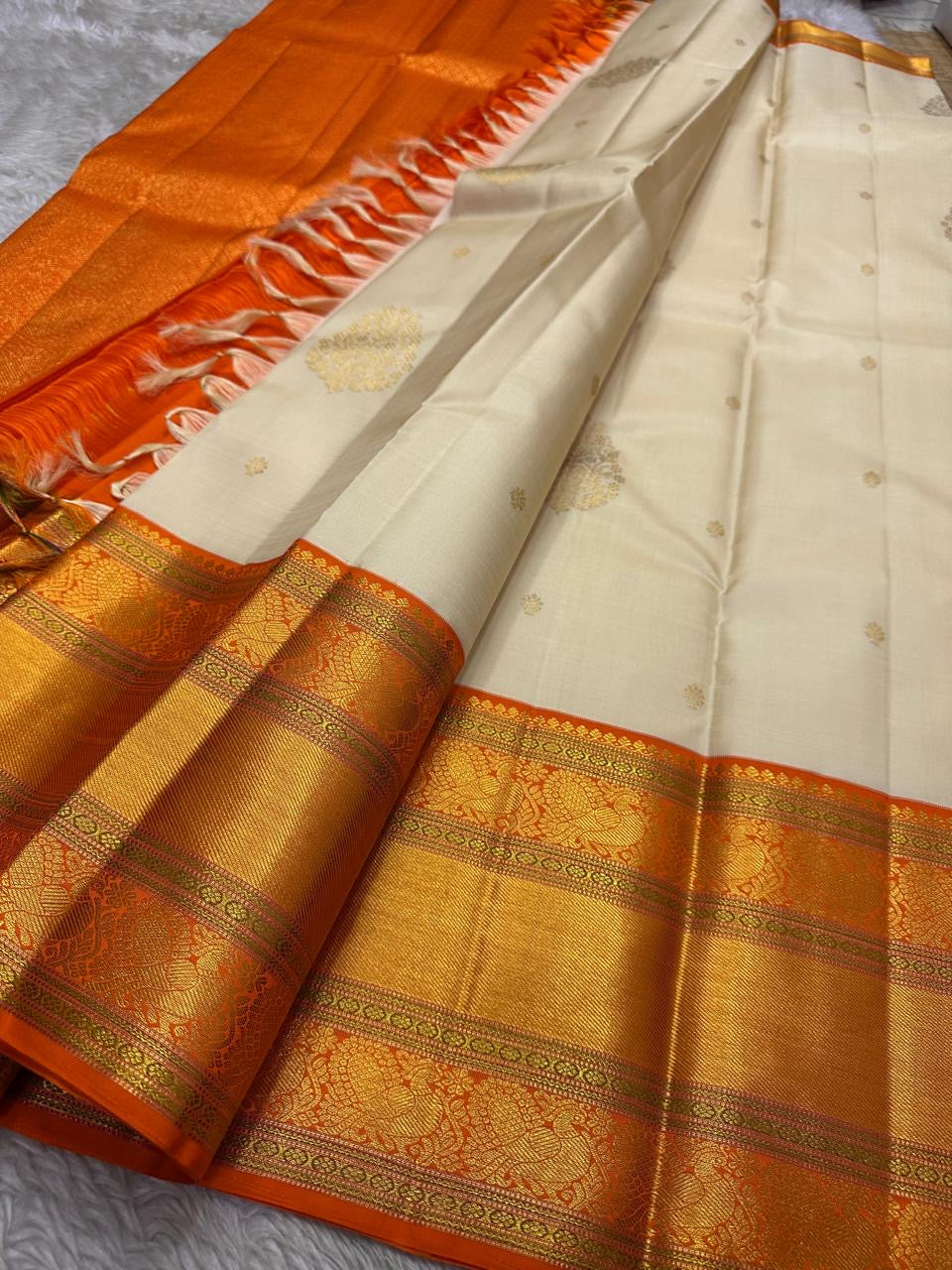 Ivory Marigold — Pure Silk Kanchipuram Saree
Pearl-Ivory Body with Gold Buttas & Kesari-Orange Peacock Zari Border ✨
Silk Mark Certified • Free USA Shipping • Ships in 2 weeks