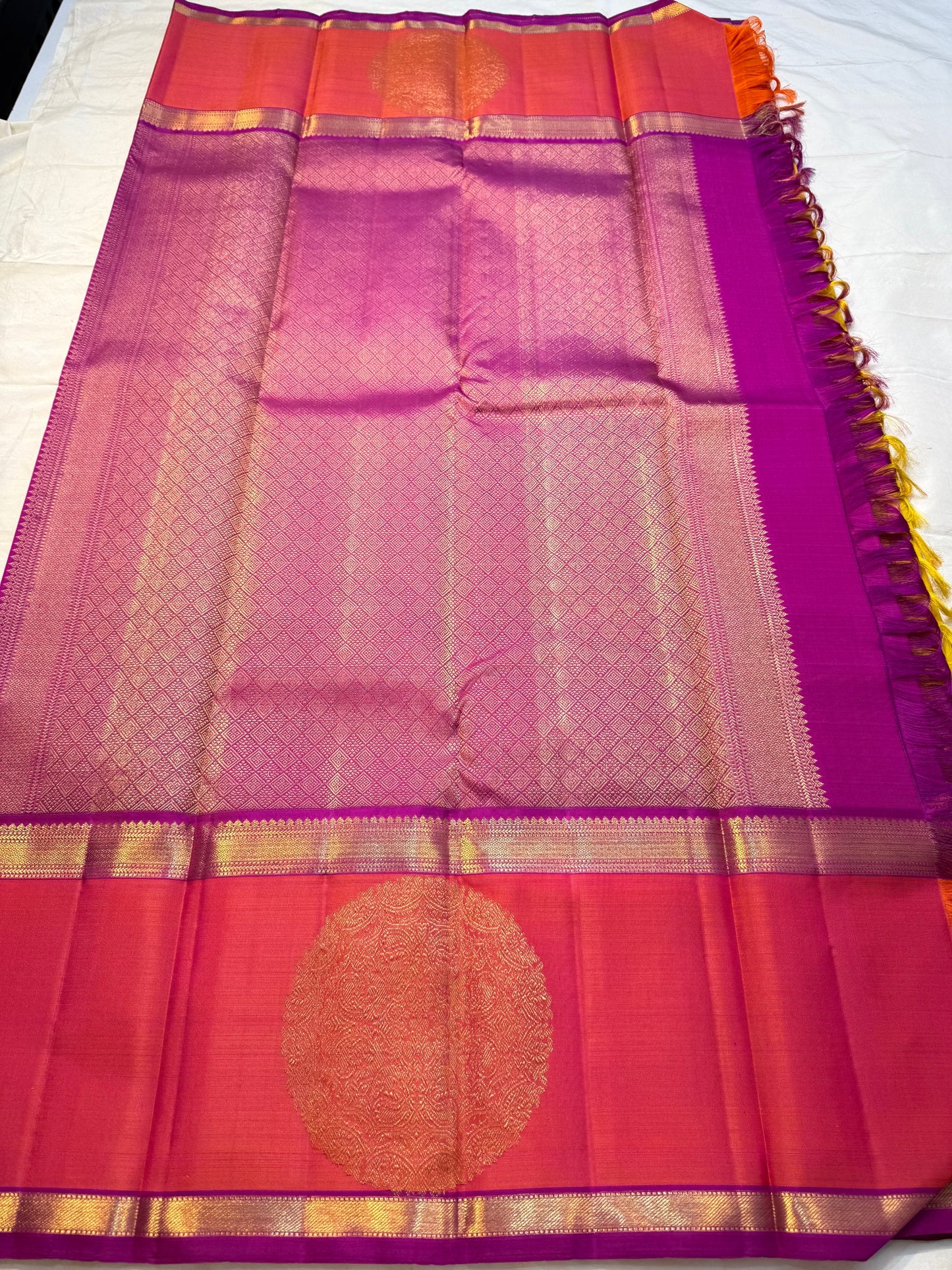 Mangai Manjal Chakram — Kanchipuram Pure Silk
Sun-yellow body with tiny zari buttas • Korvai contrast border
Rani-pink shot with purple selvedge • chakram medallions
Vaira-oosi diamond pallu with dual-tone tassels
Silk Mark Certified • Free shipping