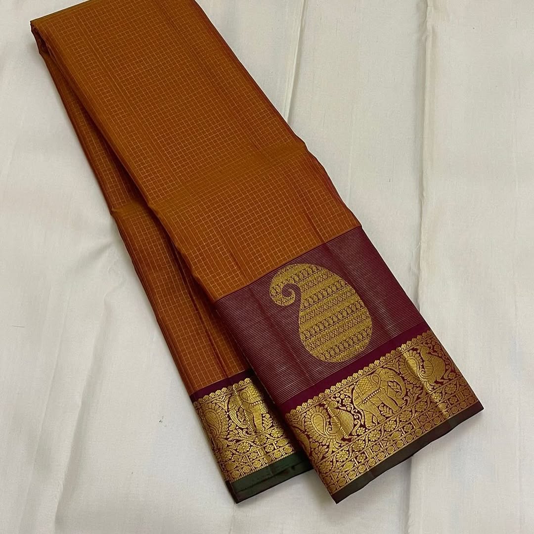 Ushas — Rust Orange Pure Kanchipuram Silk Saree
Radiant Rust Orange Oosi Kattam body with ornate Paisley 2gm Zari ✨
Arakku Red Vanasringaram, Muthuseer & Kamalam border with Fishpettu
Exquisite Arakku Red diamond-pet grid Zari pallu green selvedge