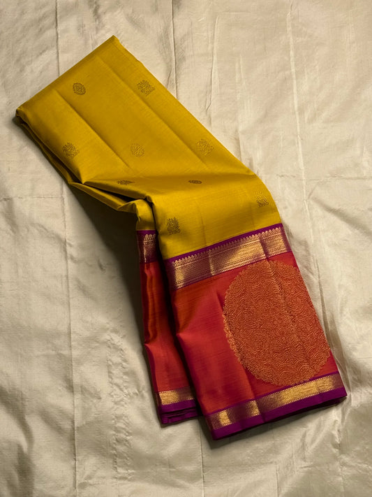 Mangai Manjal Chakram — Kanchipuram Pure Silk
Sun-yellow body with tiny zari buttas • Korvai contrast border
Rani-pink shot with purple selvedge • chakram medallions
Vaira-oosi diamond pallu with dual-tone tassels
Silk Mark Certified • Free shipping