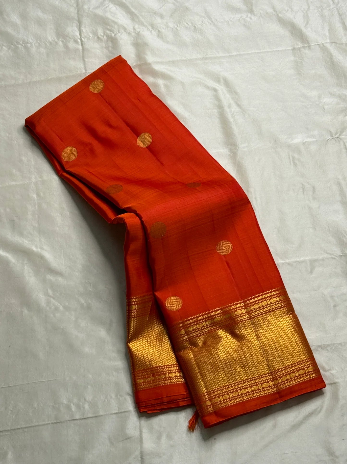 Maya
Vibrant Orange Kanchipuram Silk Saree with Lustrous Gold Coin Buttas
Handwoven Traditional Rudhraksham Seer and Intricate Arai Maadam Zari Border
Richly Crafted Pallu Featuring Elegant Gold Zari Panels for a Regal Finish