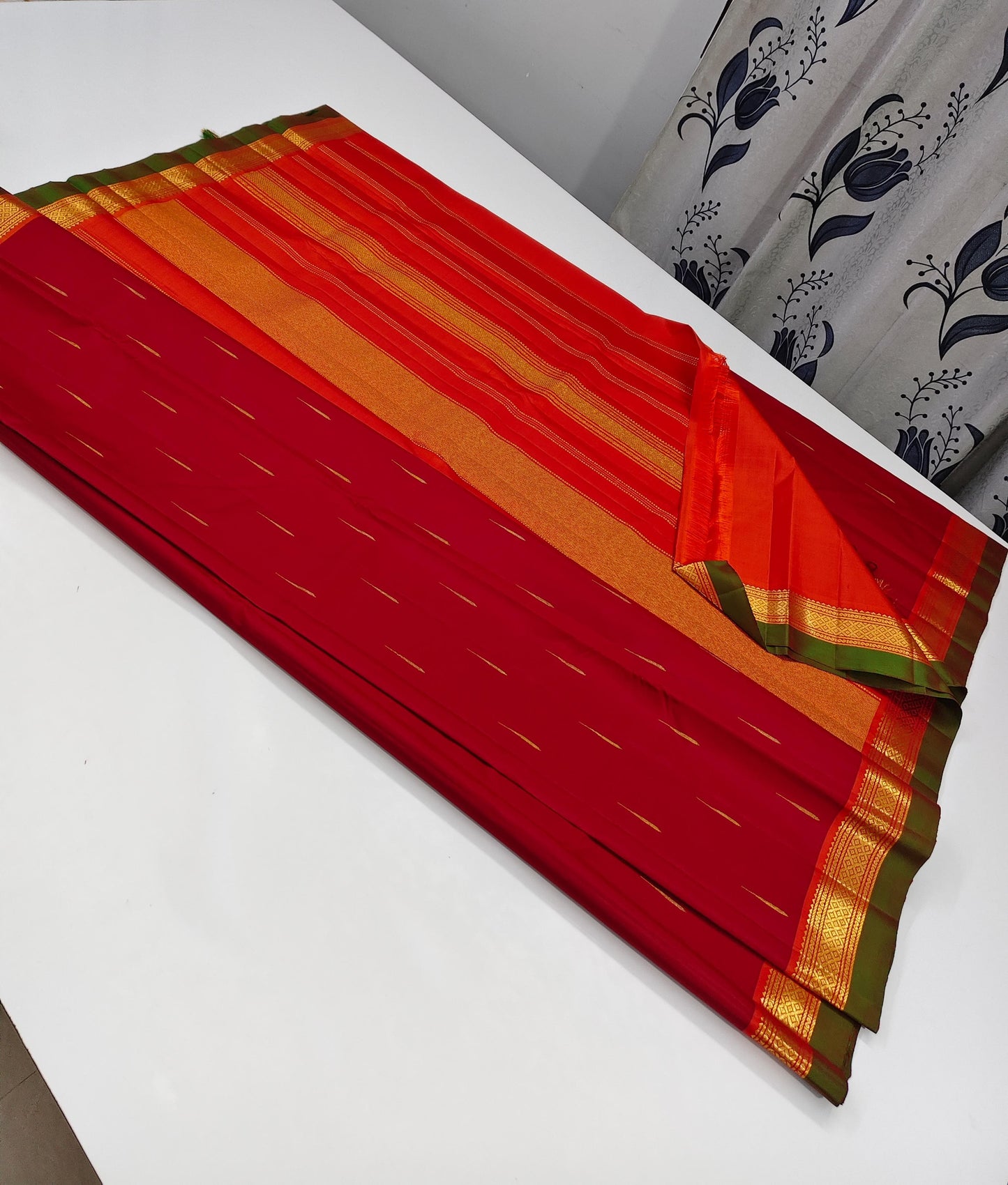 Mullai Moggu Red — Pure Kanchipuram Silk Saree
Deep kumkum-red body with mullai bud zari buttas & antique-gold border with green selvedge
Radiant orange-gold zari pallu • Silk Mark Certified • Free Shipping within USA • Ships in Two Weeks
