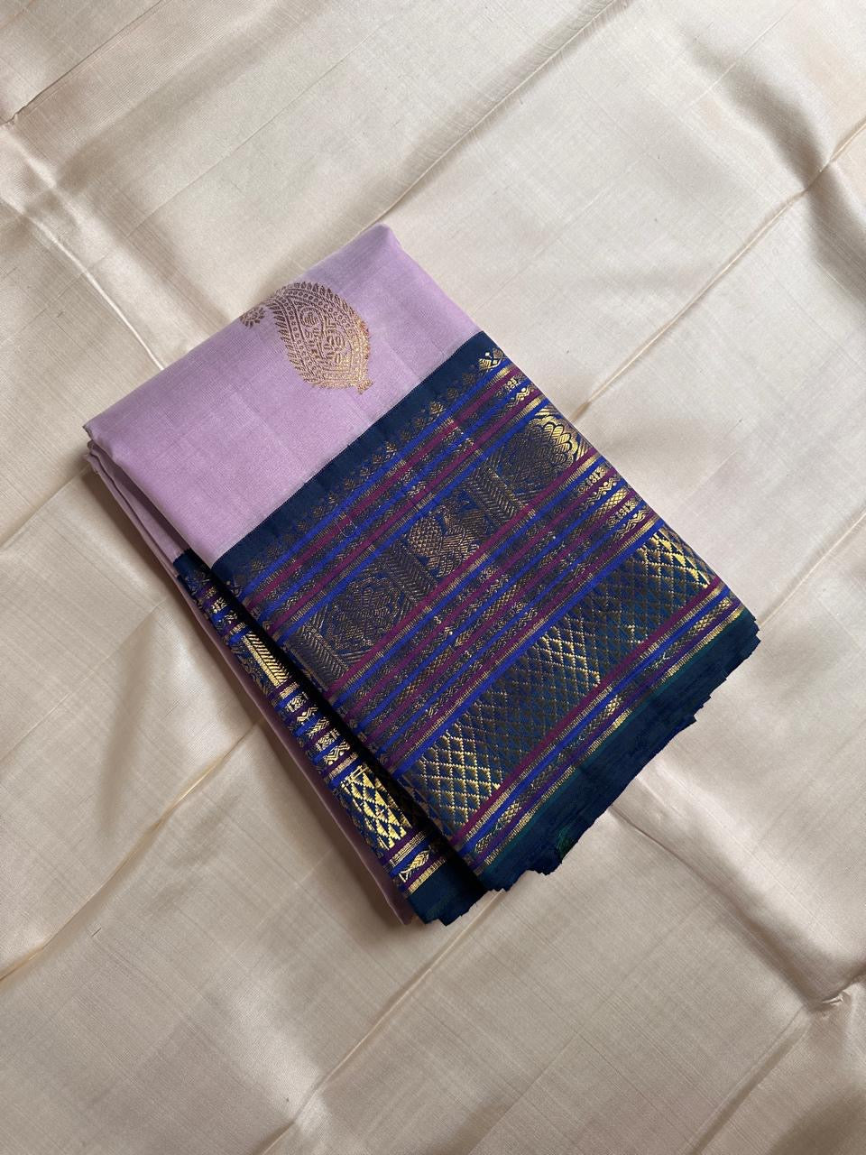 Mogra 💜✨🌿 – Lilac Kanchipuram Silk Saree with Gold Paisley Buttas, Navy Blue shot green Varisaipet Zari Border featuring Arai Madam, Vanki Pettu, Peacocks 🦚 & Contrast Silk Thread Accents