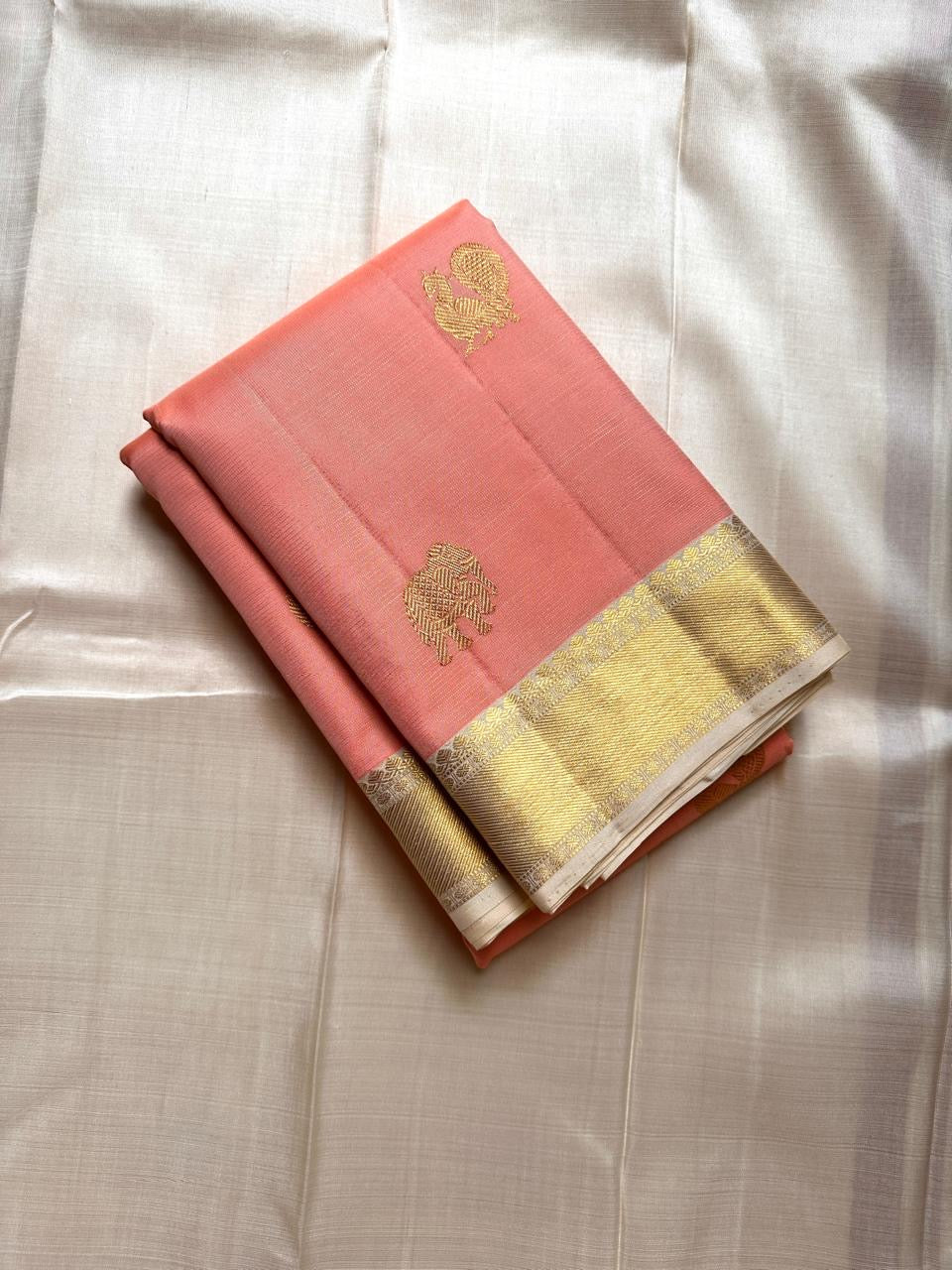Ivory Blush Meadow – Pure Kanchipuram Silk Saree
Blush-Peach Body with Gold Zari Animal Buttas
Ivory-Gold Contrast Border with Floral Motifs
Grand Ivory-Gold Brocade Pallu in Traditional Weave
Silk Mark Certified, delivery in 2 weeks