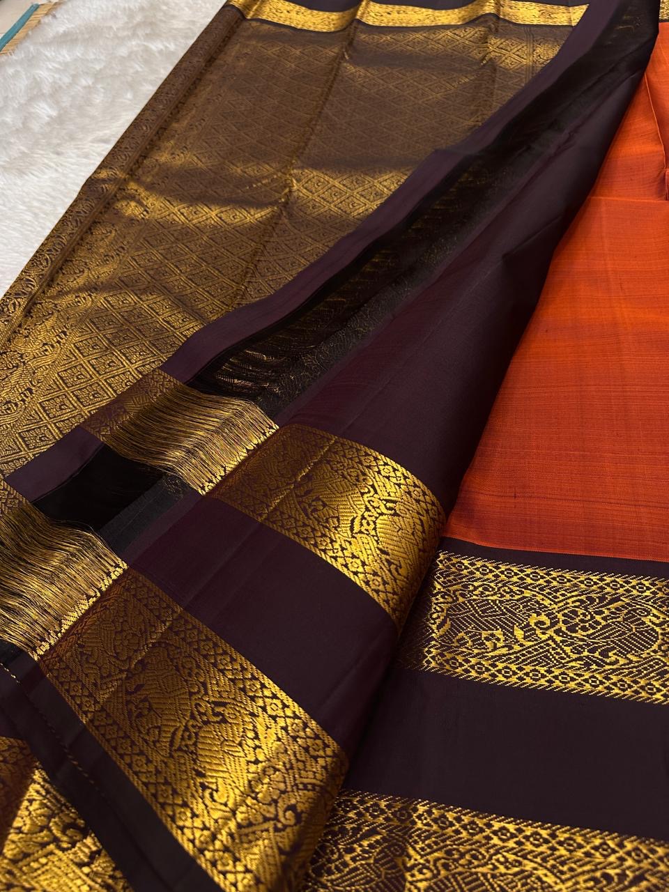 The Rust Orange Abharna: A Silk Mark Certified Kanchipuram Pure Silk Saree
with Maroon and Gold Elephant Zari Border & Rich Zari Pallu
Handwoven with Exquisite Peacock Motifs
Free Shipping within USA on this Handloom Creation
Ships in 1 Week