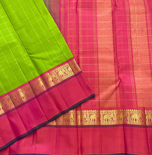 Valli Pachai – Kanchipuram Pure Silk Saree
Parrot-green body in kattam (grid) checks with subtle zari lines
Korvai contrast rani-pink borders featuring gaja (elephant) procession & temple reku motifs
Rich rani-pink zari pallu with vertical bands