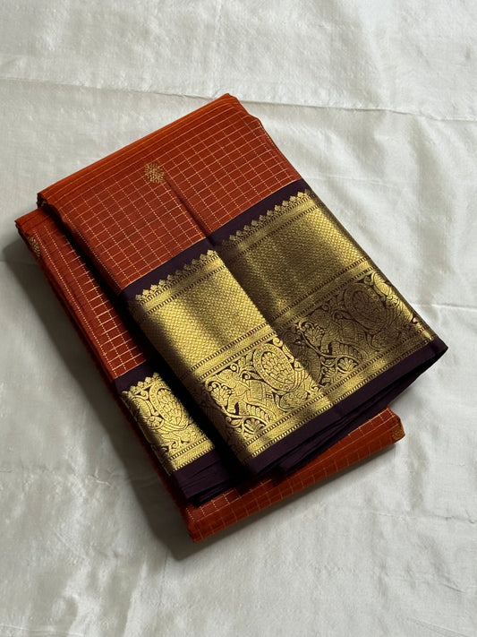 Rust Orange Kattam & Purple Korvai – Pure Kanchipuram Silk Saree
Rust-orange checks with delicate gold buttas and contrast purple korvai borders
Grand purple zari-pallu | Contrast purple blouse | Fall & Pico Done
Silk mark certified ships