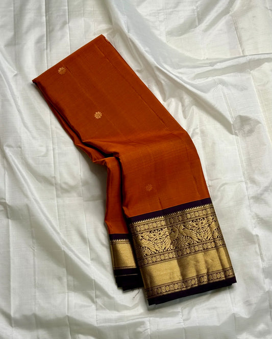 Rust Orange Annam Bloom – Pure Silk Kanchipuram
Rust-orange body with delicate zari buttas 🌸
Aubergine korvai borders with majestic Annam motifs 🪔
Grand aubergine pallu with kasu stripes & tissue weave ✨
Silk Mark Cert • Ships in Two Weeks- chk desc