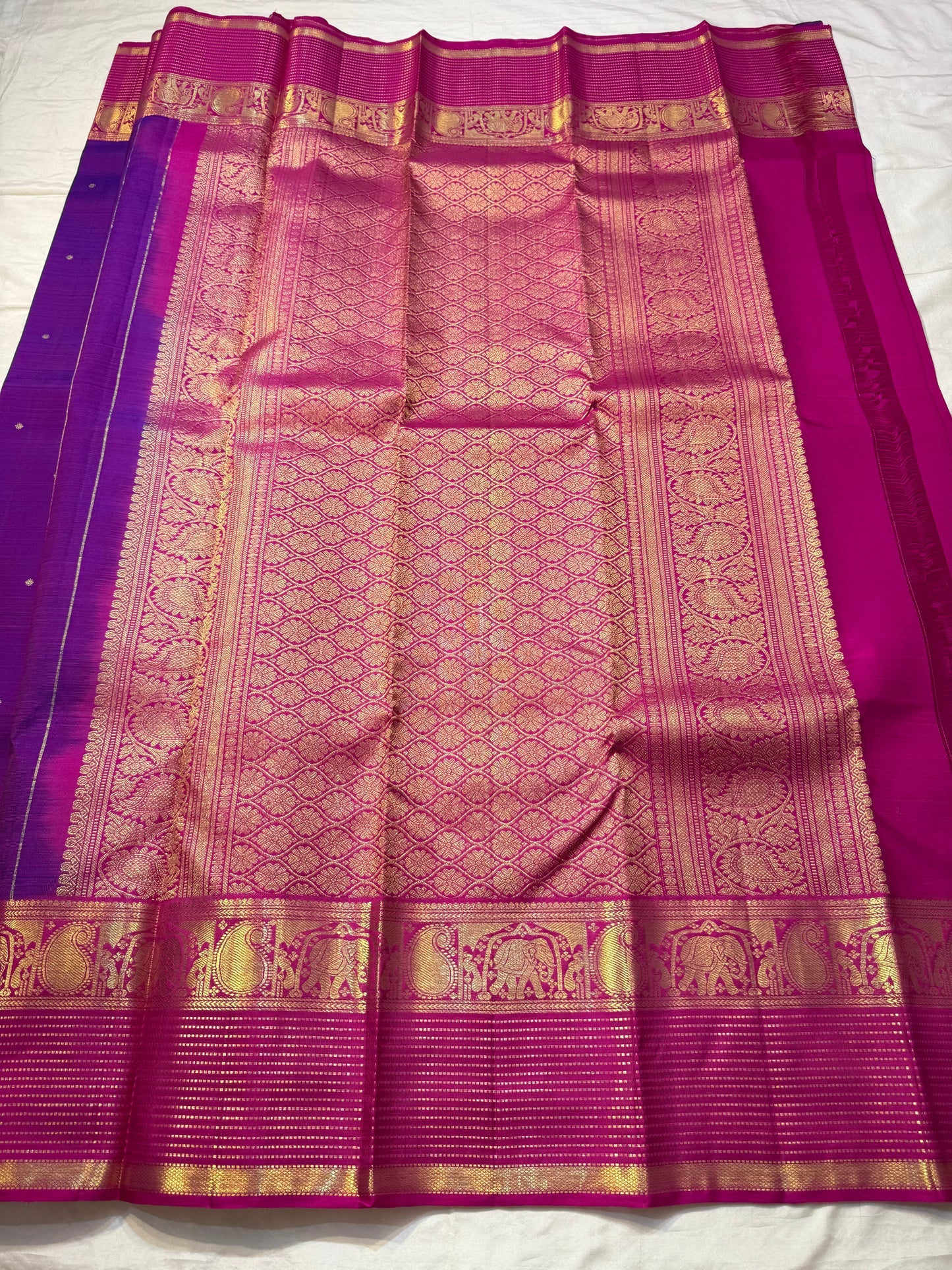 Classic Amethyst — Pure Silk Kanchipuram Saree
Royal violet body with gold muthu buttas & rani-magenta elephant zari borders
Silk Mark Certified • Free USA Shipping • Ships in Two Weeks