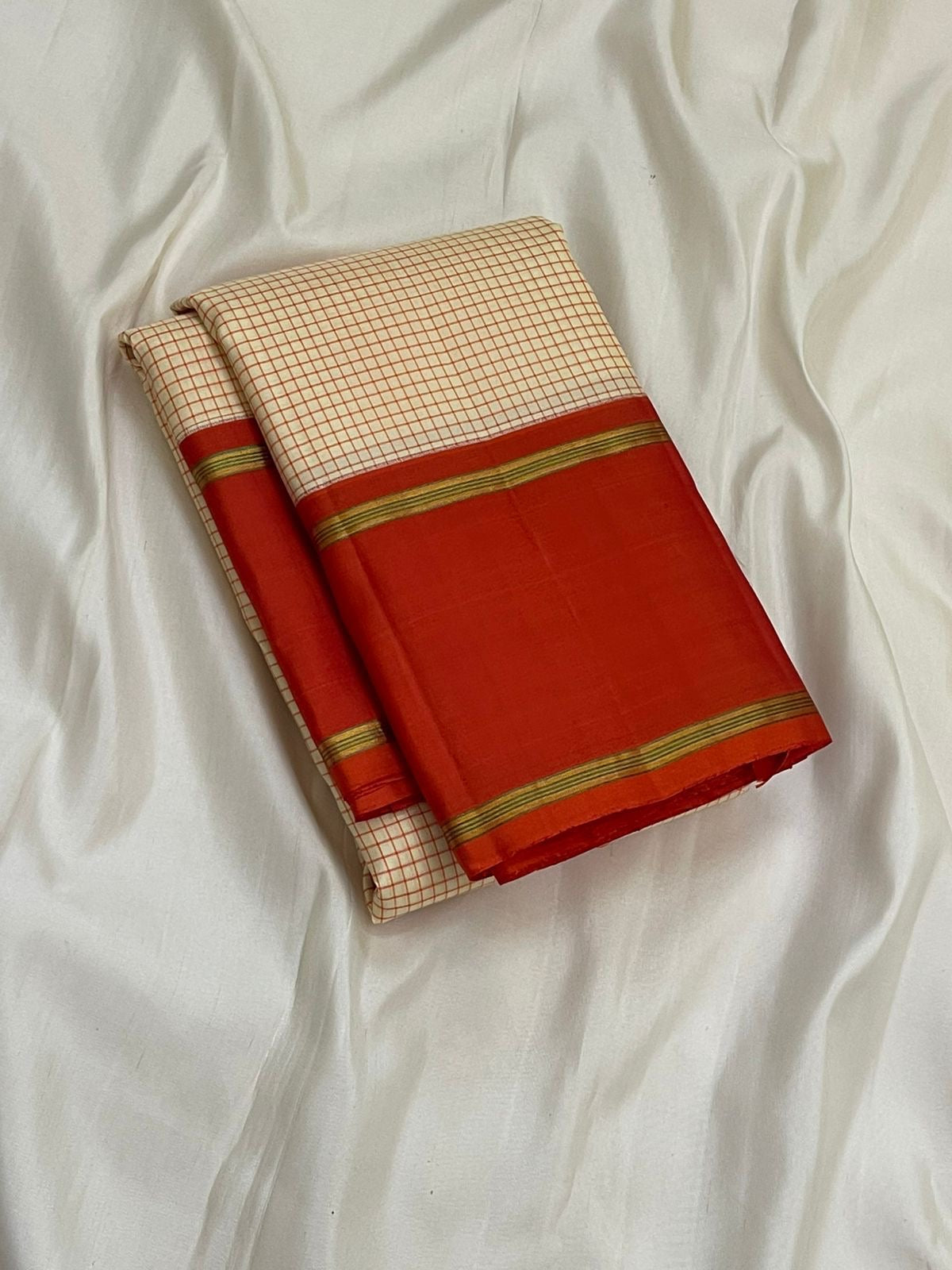 Ivory Vermillion Kattam — Pure Silk Kanchipuram Saree
Buttermilk-Ivory Body with Red Micro-Checks & Vermilion Korvai Border ✨
Gold Pin Lines, Leaf-Green Highlights & Rust Pallu • Silk Mark Certified • Ships in 1 Week ✅