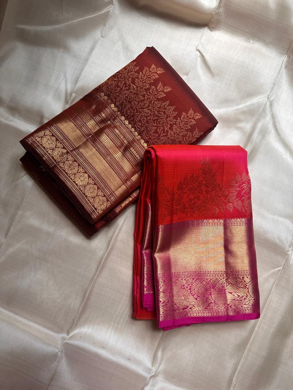 Sunset Peacock – Pure Kanchipuram Silk Saree
Sunset-Orange to Fuchsia Body with Zari Buttas ✨
Gold Zari Peacock Panel Border with Leafy Creeper Motif
Grand Fuchsia Brocade Pallu with Lattice Jaal Weave
Silk Mark Certified, delivery in 2 weeks