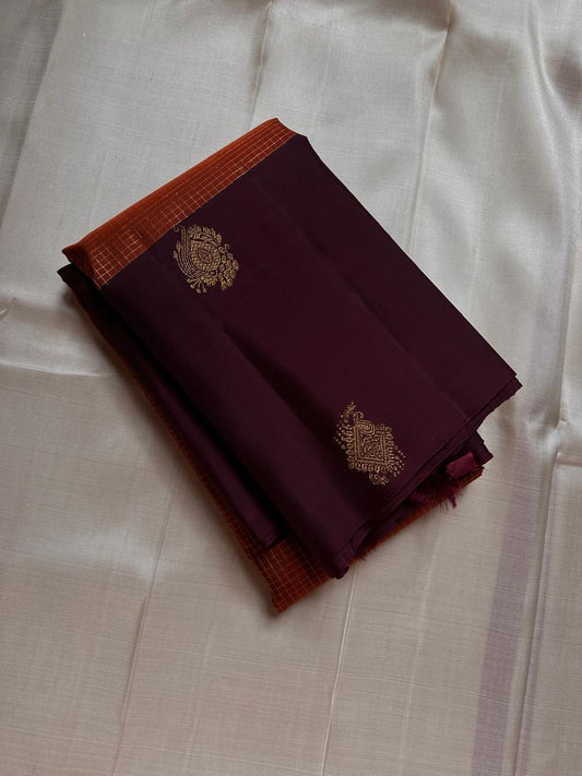 Rust Orange & Wide Broad Silk Korvai – Pure Kanchipuram Silk Saree
Deep wine body adorned with gold ambi buttas for subtle elegance
Contrast rust-orange wide korvai border with podi-kattam micro checks
Grand wine pallu with full-zari diamond jaal