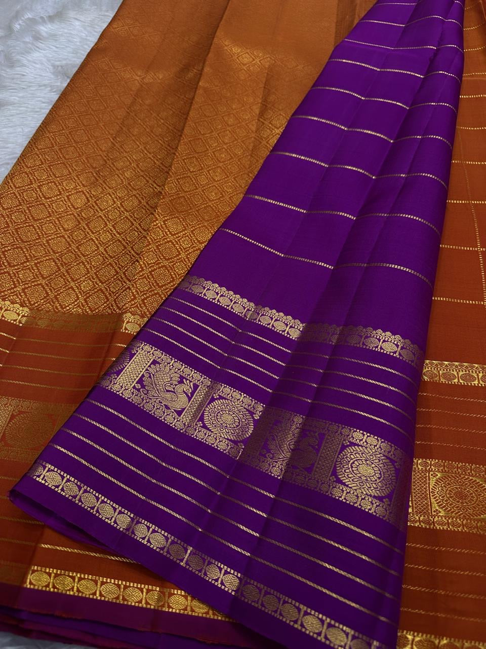 Pankajam 🌺 – Burnt Orange Kanchipuram Silk Saree with Zari Kattam, Dashed Lines, Kolam Motifs, Varisaipet Border with Thandavalam Zari Stripes, Rudrakshpet, Annam & Kamalam Motifs, Deep Magenta-Purple Selvedge & Ornate Pallu