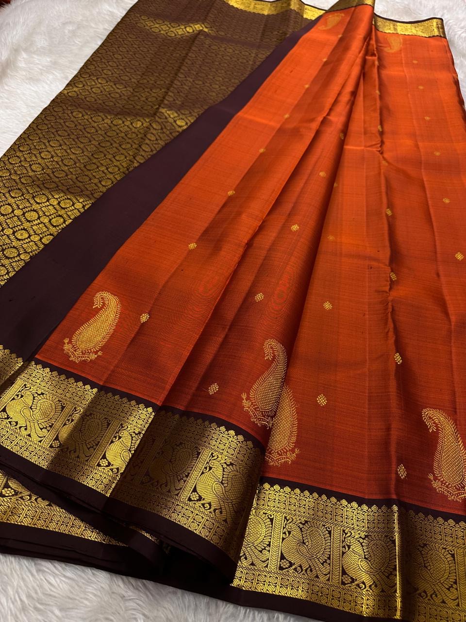 Rust Orange Paisley — Pure Silk Kanchipuram Saree
Rust-orange body with gold coin buttas & grand paisley motif, deep coffee borders with peacock zari panels & temple edge.
Rich zari pallu, contrast blouse; Silk Mark Certified ✅ Free USA Shipping 🇺🇸 Ship