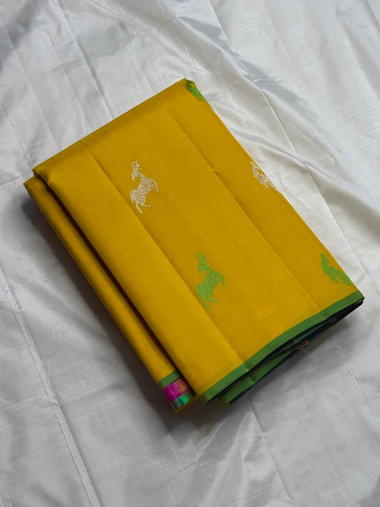 Silk Thread Deer Butta — Muted Yellow Pure Silk Kanchipuram Saree
Turmeric-yellow body with silver & parrot-green silk deer motifs · Rani-pink zari pallu with temple motifs · Green selvedge korvai border finish ✨
Silk Mark Certified ✅ | Fall & Pico Done ✅
