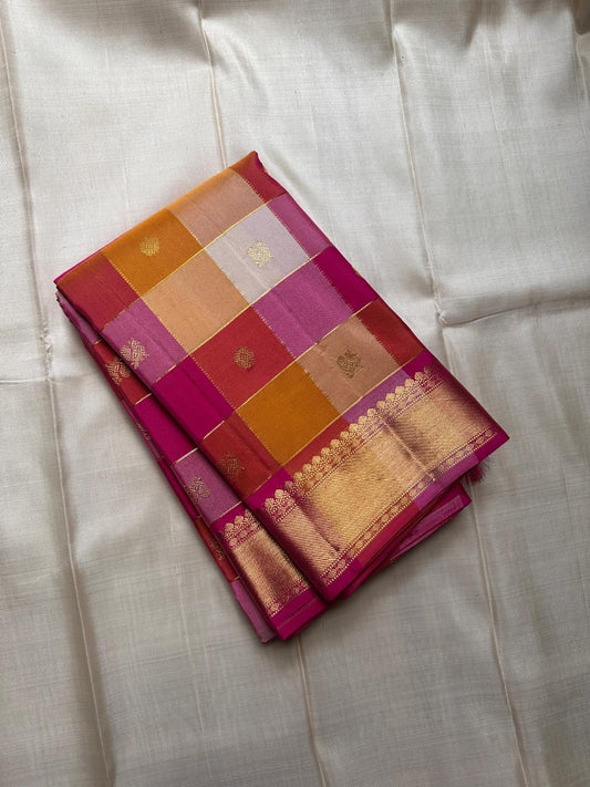 “Moggu”- Paalum Pazhamum is a soft pastel silk saree in pink, mustard, and cream—finished with mayil chakram  butta  and bold Bavanji borders.