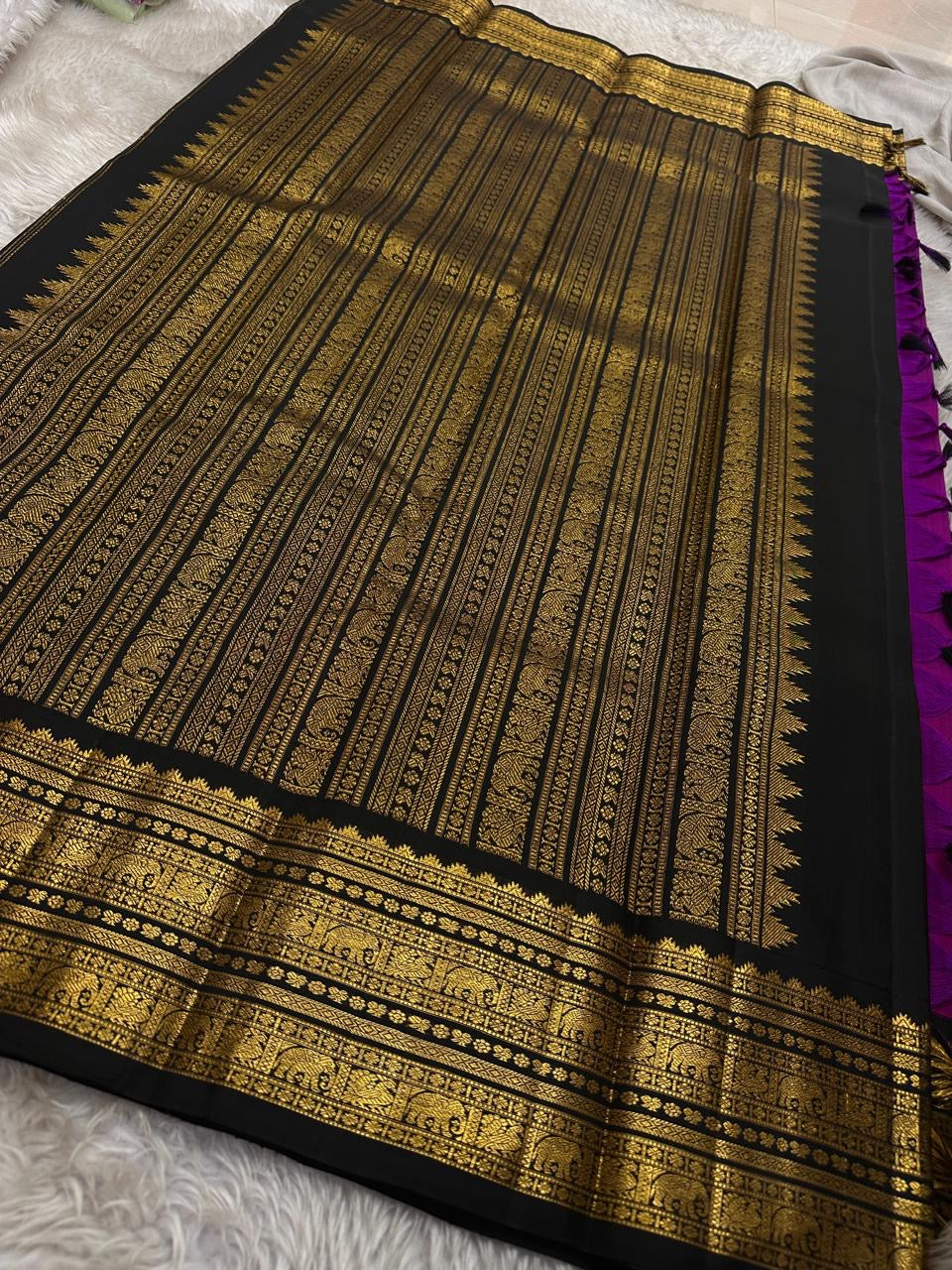 Menaka ✨ Draped in vibrant purple , its body shines with golden Yazhi motifs enshrined in Sorgavaasal arches. The contrasting black Korvai border, alive with elephants, vines, and temple motifs in zari and lavish Pallu , silk mark certified ❤️