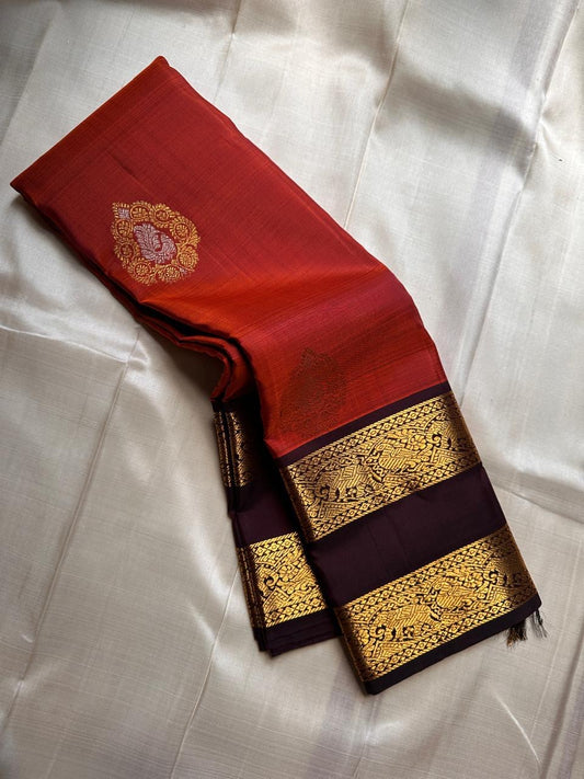 The Rust Orange Abharna: A Silk Mark Certified Kanchipuram Pure Silk Saree
with Maroon and Gold Elephant Zari Border & Rich Zari Pallu
Handwoven with Exquisite Peacock Motifs
Free Shipping within USA on this Handloom Creation
Ships in 1 Week