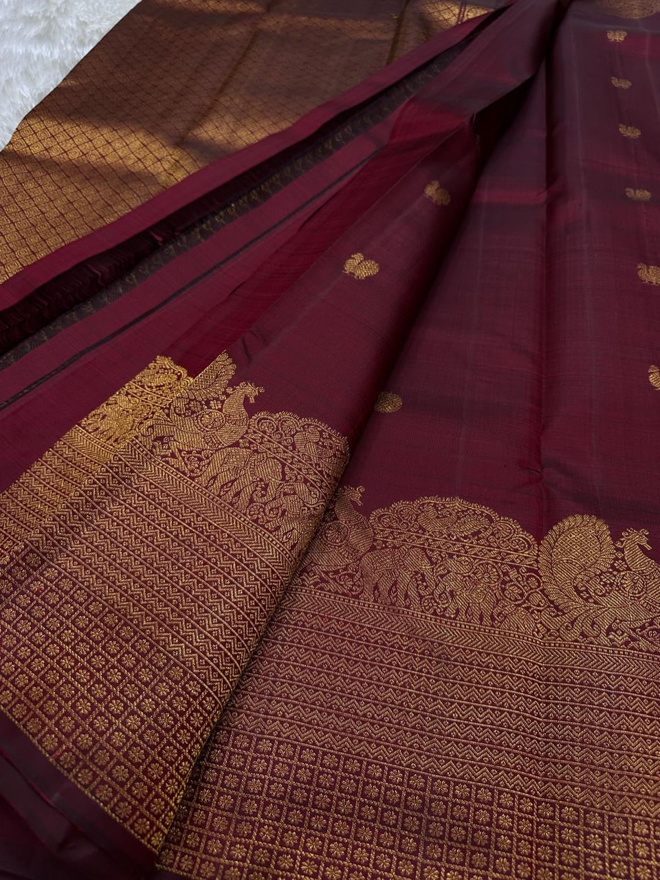 Lotus Glow — Maroon Brown | Pure Kanchipuram Silk Saree
A rich maroon-brown canvas with gold zari peacocks, elephants & lotus motifs 🌸
Silk Mark Certified • Free USA Shipping • Ships in Two Weeks