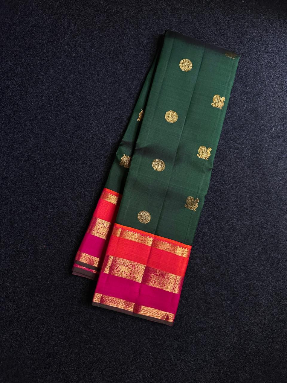 Varna Jaalam Green — Pure Silk Kanchipuram
Bottle-green body with gold chakram & mayil buttas, korvai pink-orange border
Silk Mark Certified • Free USA Shipping • Ships in Two Weeks ✅