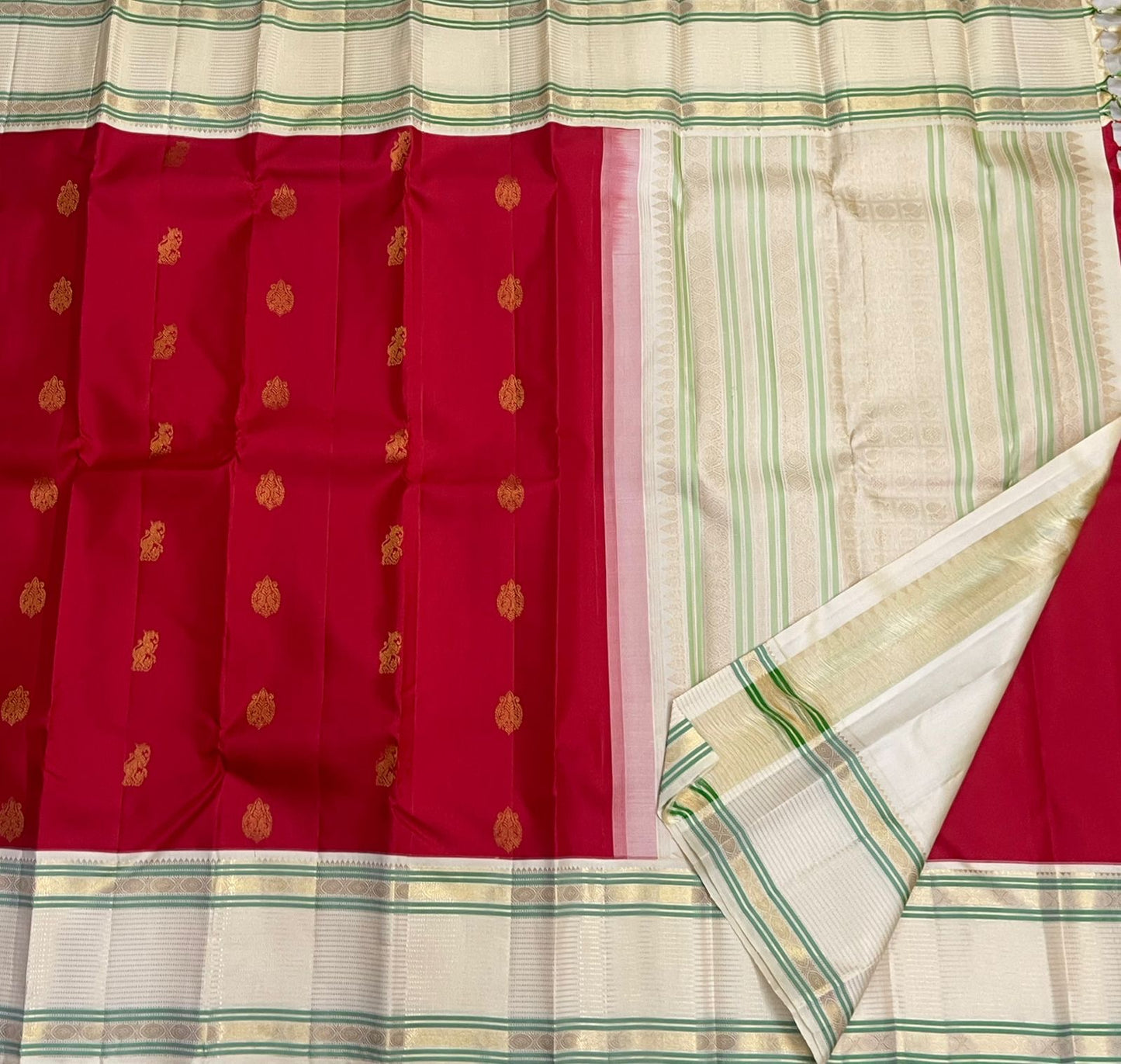 Yazhi Venpattu — Pure Silk Kanchipuram
Kumkum-red body with gold mankolam buttas & ivory korvai borders in mint-green lines ✨
Silk Mark Certified • Ships in Two Weeks • Free Shipping within USA