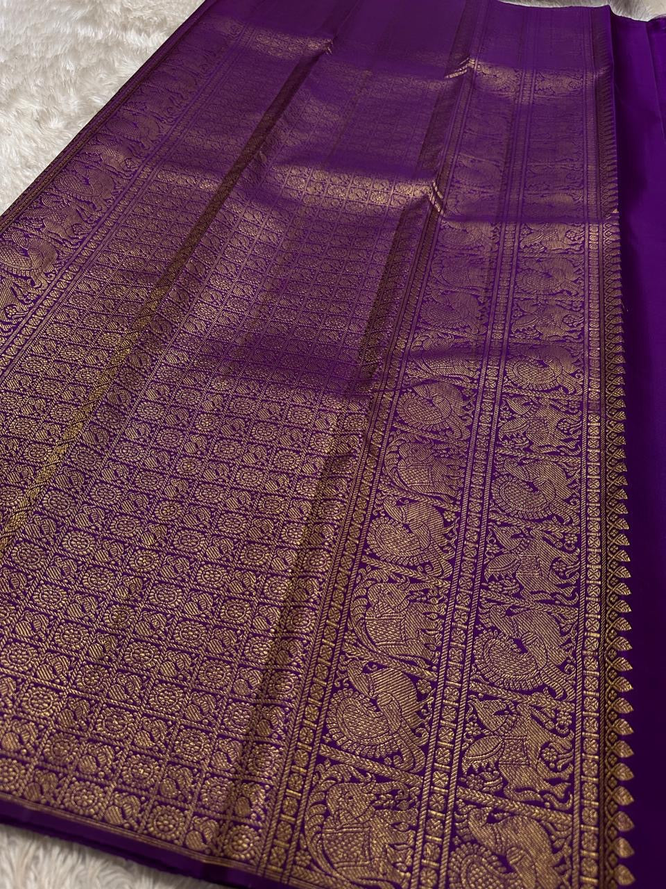 Lotus Glow — Violet | Pure Kanchipuram Silk Saree
A royal violet canvas with antique-gold zari peacocks, elephants & lotus motifs ✨
Silk Mark Certified • Free USA Shipping • Ships in Two Weeks