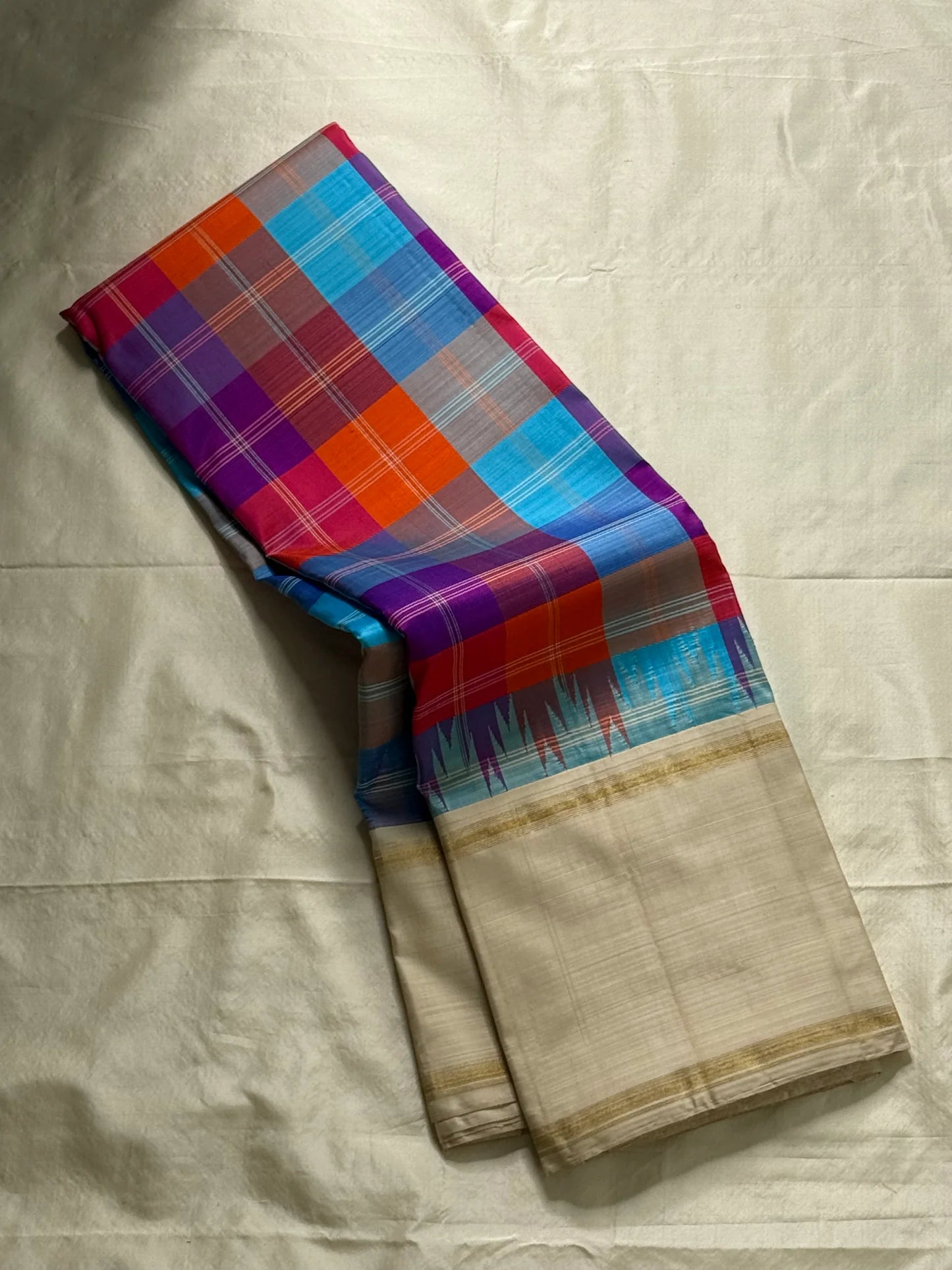 Venpattu Kattam Thazampoo Reku – ivory/venpattu borders with multicolor kattam (checks) body
Pure Kanchipuram silk • rani pink, tangerine, purple, sky blue & steel grey checks with thazampoo reku edging
Ivory pallu with gold tissue stripes & multicolor